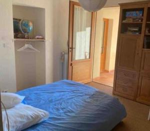 1 dormitorio con 1 cama con sábanas azules y puerta en Maison avec vue imprenable, en Millau