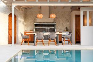 una cocina con mesa y sillas junto a una piscina en My Mediterranean Corfu Luxury Villa with Private Swimming Pool en Kontokali