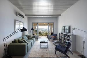 a living room with a couch and chairs and a table at Paleokastritsa Red Gate Flat in Paleokastritsa
