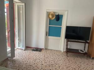 Zimmer mit einem Flachbild-TV und einer Tür in der Unterkunft Fishermans House in Khlóï