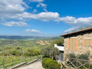 a stone house with a view of the rolling hills at Il Poggio da Katia in Saturnia