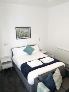 een slaapkamer met een groot bed en een bank bij Southside Street Apartments in Plymouth