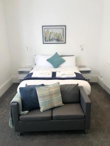 een slaapkamer met een bed met een bank erin bij Southside Street Apartments in Plymouth