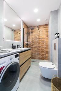a bathroom with a washing machine and a shower at Apartment City Centre Netflix- GreenPark - River in Olsztyn