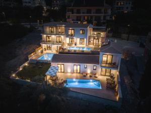 Nemesis Luxury Villas في Apolpaina: اطلالة جوية على بيت فيه مسبح بالليل