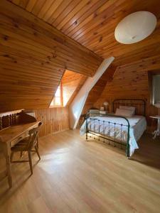 sypialnia z łóżkiem i drewnianym sufitem w obiekcie Le Béarn sous les toits w mieście Nay