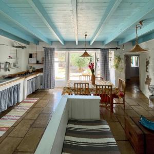 Una cocina y un comedor con techos azules y una mesa. en Casa Vacanze Capurre "Trulli e Pajare a due passi dal Pizzo", en Gallipoli