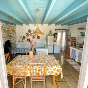 una sala da pranzo con tavolo e una cucina di Casa Vacanze Capurre "Trulli e Pajare a due passi dal Pizzo" a Gallipoli