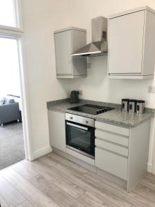 een keuken met witte kasten en een fornuis met oven bij Southside Street Apartments in Plymouth