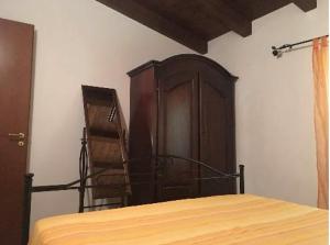 um quarto com uma cama e um armário de madeira em Il Nido delle Gazze em Marina di Camerota