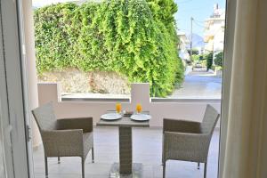 a table and chairs on a patio with a window at Artemis No1 Apartment in Kissamos