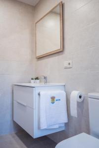a bathroom with a white sink and a mirror at SuitesNature EcoCamp Beche in Santa Eulalia