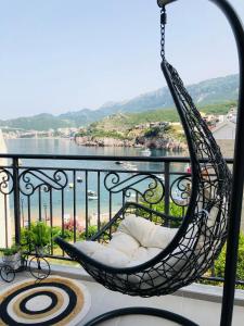 a hammock on a balcony with a view of the water at Apartment Seaside in Pržno