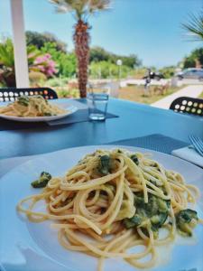 a plate of pasta with vegetables on a table at Villa Sibilla in Bacoli