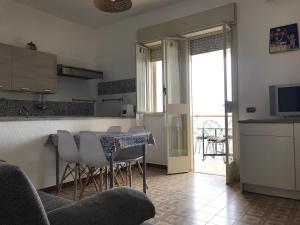 a kitchen and living room with a table and chairs at 2 bedrooms apartement at Sciacca 400 m away from the beach with sea view furnished garden and wifi in Sciacca