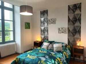 a bedroom with a bed with a colorful blanket at Appartement chaleureux de 82M2 proche de Vulcania in Pontaumur