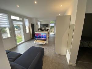 a living room with a couch and a flat screen tv at Boulevard de lattre de tassigny RDCh in Saint-Paul-lès-Dax