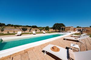 a swimming pool with lounge chairs and a swimming pool at HelloApulia - Typical Cottage Lamia delle Murge in Ostuni