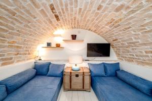a living room with blue couches and a brick wall at HelloApulia - Typical Cottage Lamia delle Murge in Ostuni