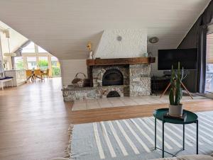 a living room with a stone fireplace and a tv at Rheinquartier Küssaberg Rheinheim in Küssaberg