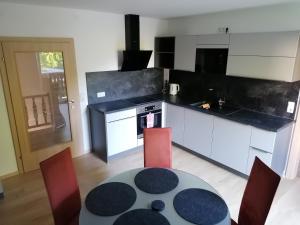 a kitchen with a table and red chairs in a room at Apartment Hörmann in Ardning