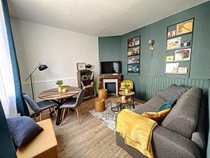 een woonkamer met een bank en een tafel bij Good Vibes only apparts "Music & Vintage House"- Paris in 15 mn - 4 pax in Groslay