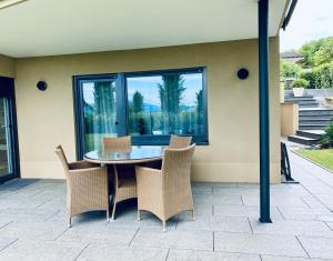 eine Terrasse mit einem Tisch, Stühlen und einem Fenster in der Unterkunft Ferienwohnung Jolene in Weil am Rhein