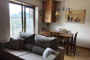 a living room with a couch and a dining room table at Lovely triplex apartment in La vall de Boi in Pla de l'Ermita