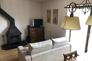 a living room with a white couch and a fireplace at Lovely triplex apartment in La vall de Boi in Pla de l'Ermita