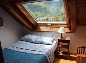 1 dormitorio con 1 cama y ventana grande en Lovely triplex apartment in La vall de Boi en Pla de l'Ermita