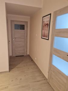 een lege kamer met een deur en twee ramen bij Apartament w Augustowie in Augustów