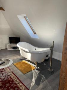 Altes Pastorat am Husumer Hafen في هوسوم: حوض استحمام أبيض في غرفة مع سقف