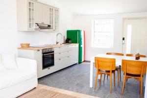 uma cozinha com uma mesa e um frigorífico verde em Rösholmens Havsboende em Kungshamn
