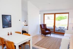 a living room with a white table and a chair at Rösholmens Havsboende in Kungshamn