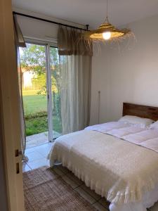 - une chambre avec un lit et une porte coulissante en verre dans l'établissement Grand appartement en résidence calme avec piscine, à Saint-Paul-lès-Dax