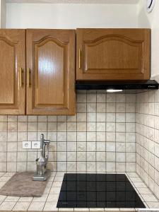 a kitchen with wooden cabinets and a sink at Grand appartement en résidence calme avec piscine in Saint-Paul-lès-Dax