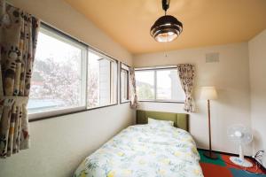 um quarto com uma cama e uma janela em 旭川美瑛 Sakura 西神楽 em Asahikawa