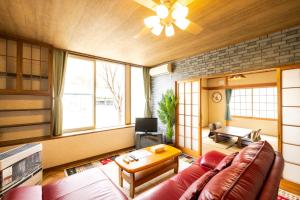 a living room with a couch and a table at 旭川美瑛 Sakura 西神楽 in Asahikawa