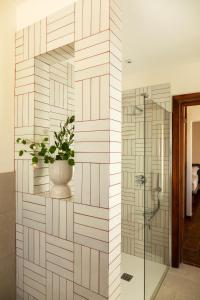 a bathroom with a glass shower with a potted plant at Pozzo Traverso Casale in Leporano Marina