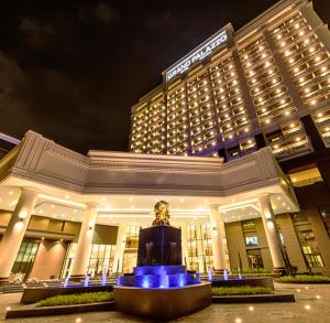 a building with a statue in front of it at night at Grand Palazzo Hotel - SHA Extra Plus in Pattaya