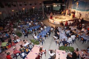 a crowd of people sitting at tables in a large room at Apartment 5, first floor in Rogoznica +18 photos