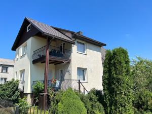 a house with a balcony on the side of it at Topoliu 16 guesthouse in Šventoji