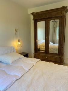 - une chambre avec une commode et un lit avec un miroir dans l'établissement Grand appartement en résidence calme avec piscine, à Saint-Paul-lès-Dax