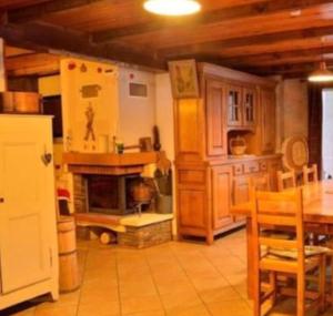 een keuken met een open haard en een tafel en stoelen bij Maison de 4 chambres avec jardin amenage et wifi a Villarembert a 2 km des pistes in Villarembert