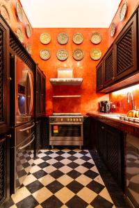 a kitchen with orange walls and a checkered floor at Palais El Roucar in Marrakesh