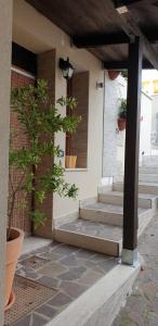 a porch with stairs and potted plants on it at Masangy's Studio in San Giacomo degli Schiavoni