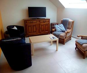 a living room with a tv and a table and chairs at Maison de 2 chambres avec jardin amenage et wifi a Cast in Cast