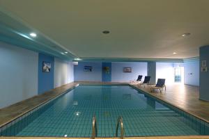 a swimming pool in a building with blue walls at Eleni Holiday Resort in Paphos City