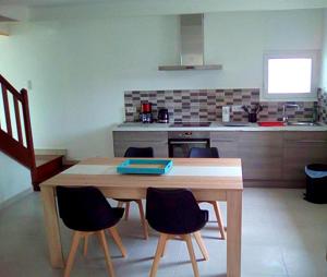 a kitchen with a wooden table and some chairs at Maison de 2 chambres avec jardin amenage et wifi a Cast in Cast