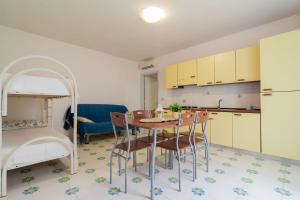 cocina y comedor con mesa y cama en Residence La Perla - Opale, en Pizzo